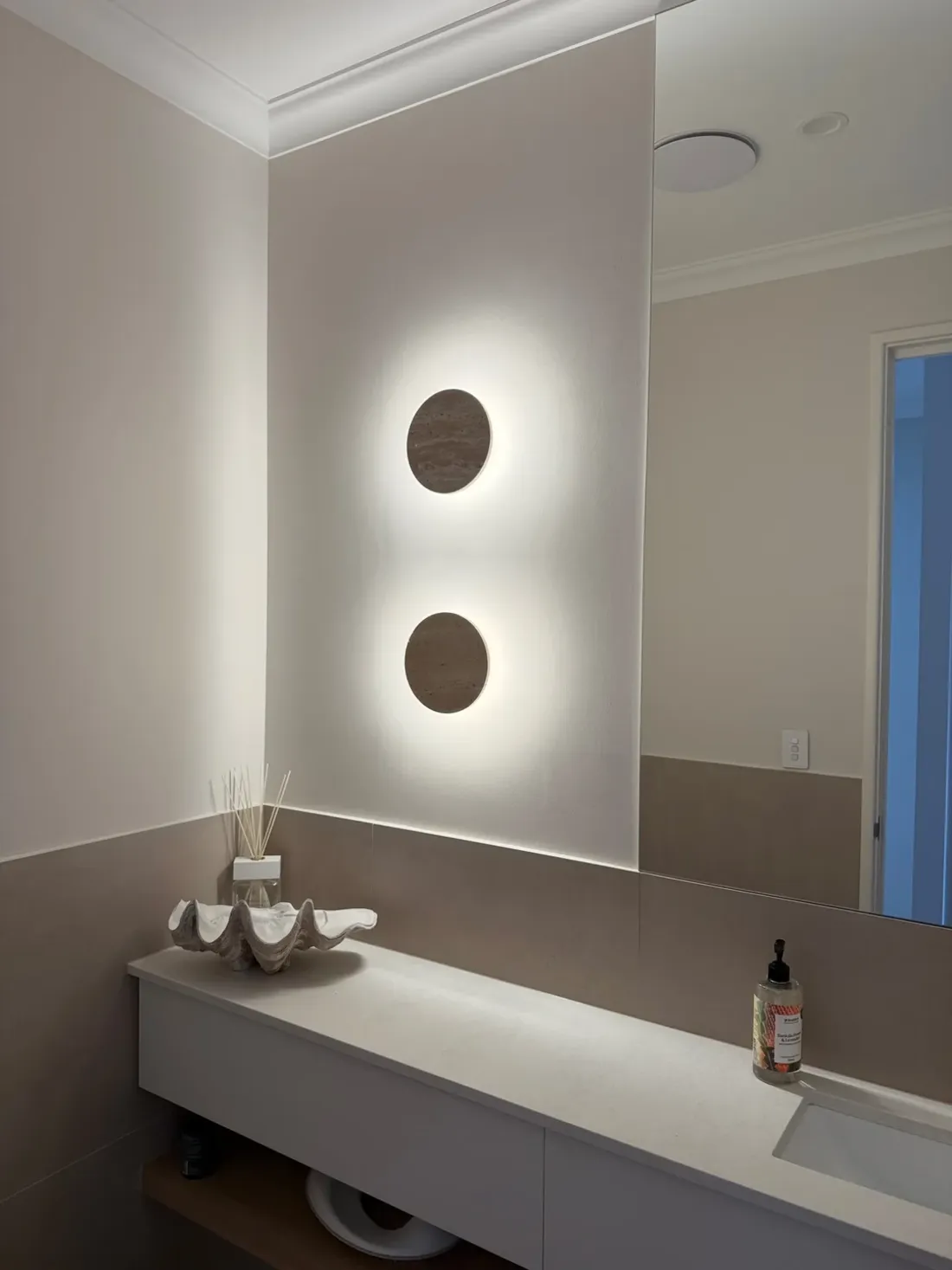 Two round wall lights above a bathroom vanity at a Baldivis home, installed by SolArk Electrical