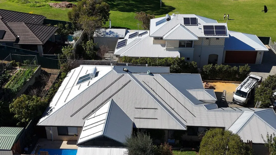 Rooftops across Beaconsfield, several carrying solar panels, seen from above