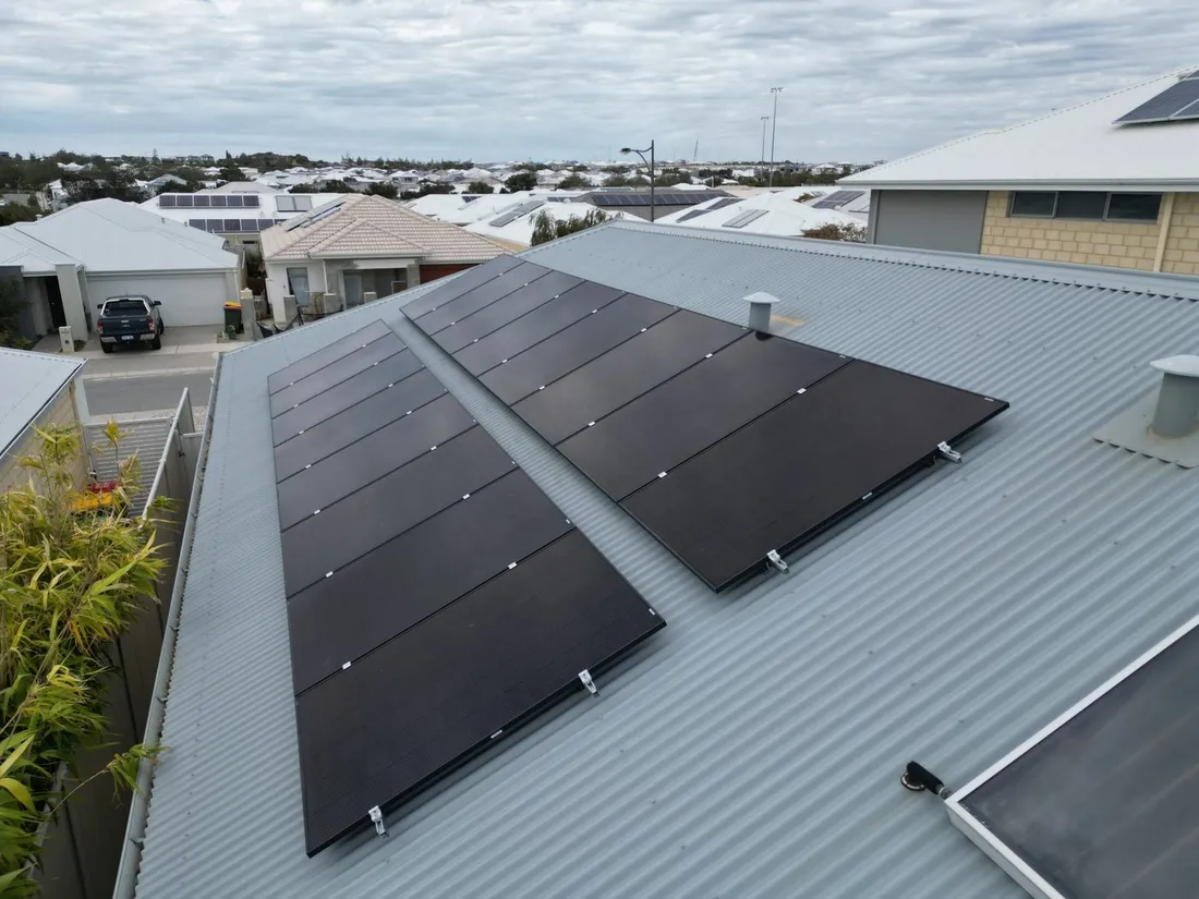 Two rows of all-black solar panels on a grey Colorbond roof, seen from above