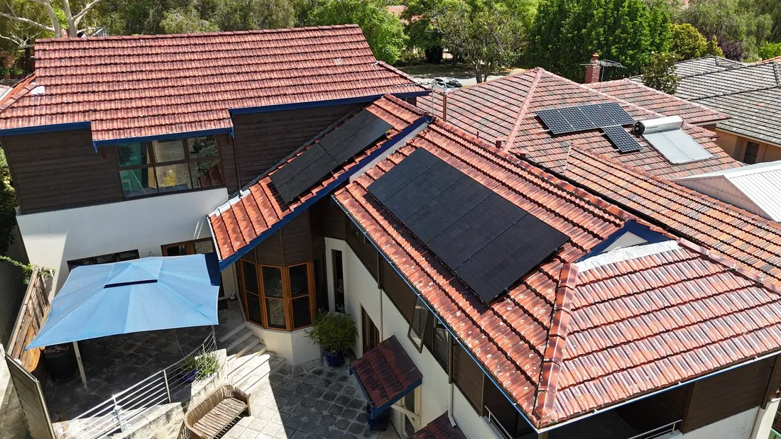Solar panels across several planes of a tiled roof, seen from above