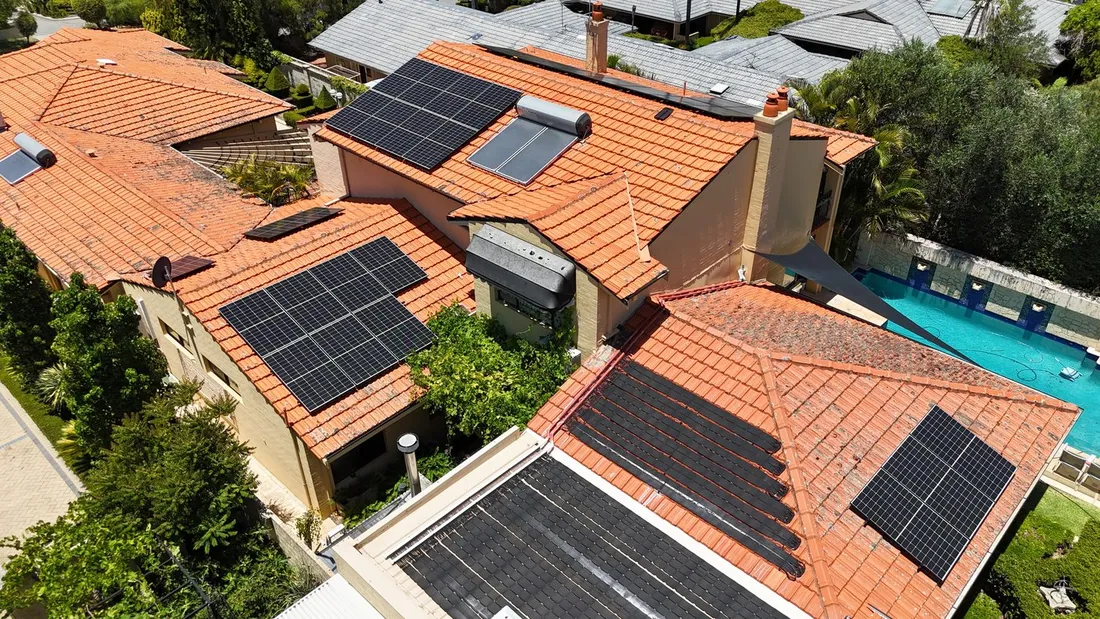 Solar panels across the tiled roof of a large Yokine home with a pool, seen from above