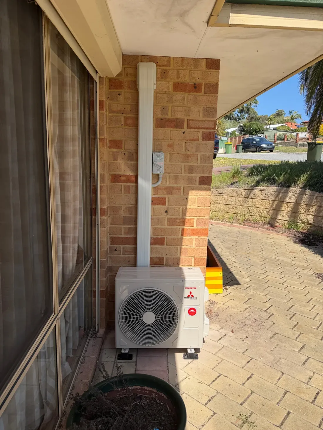A split system outdoor unit with a neat pipe cover up the wall at a Yangebup home, installed by SolArk Electrical