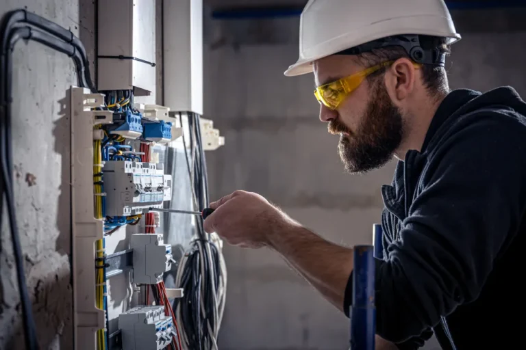 A male electrician working on a switchboard.