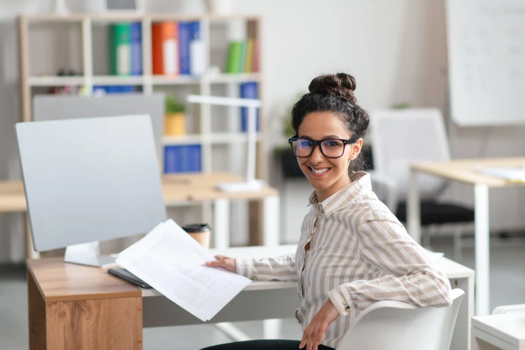 A cheerful manager from an electrical services company checking documents in the office.