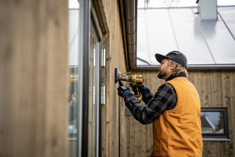 A male electrician installing an electrical box.