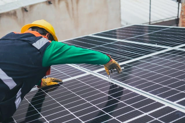 A technician installing solar panels on a roof