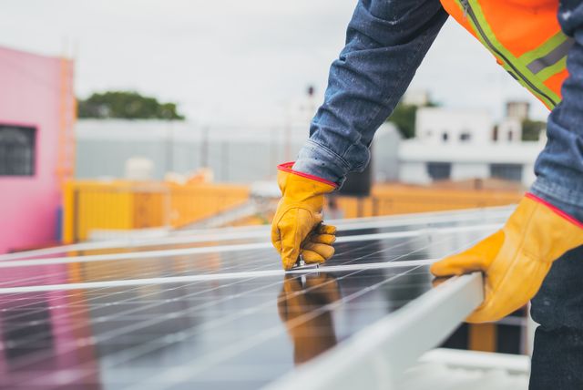 Technician installing a solar panel system on a residential roof as part of a solar battery price and energy storage solution in Perth.