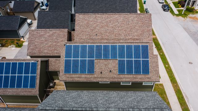 Overhead view of suburban home roofs with solar panels.